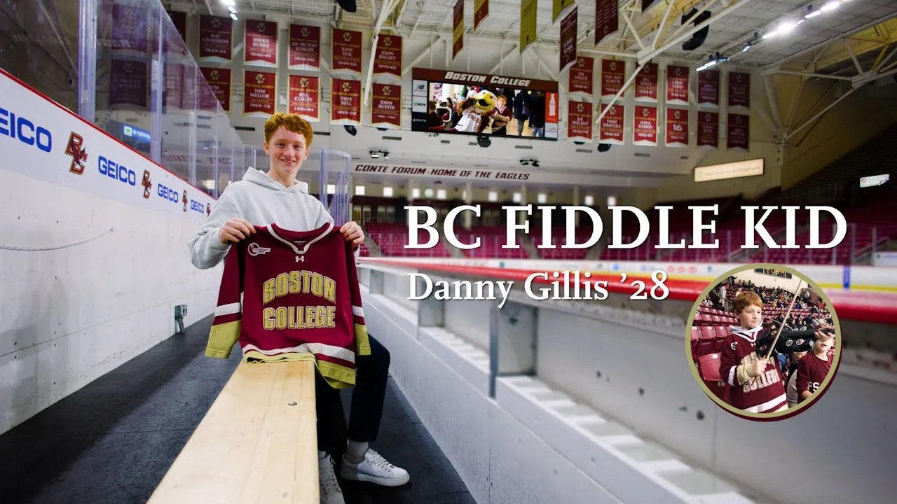 Dan Gillis holding a ϱ hockey jersey in sitting in Kelley Rink